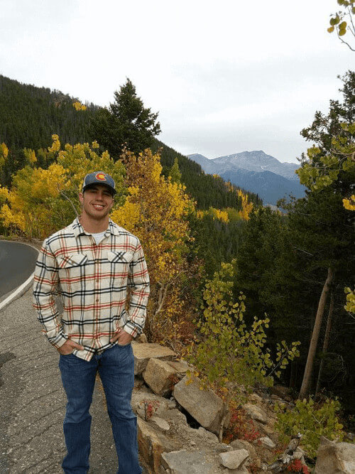 Cale standing in front of yellow aspens and mountains
