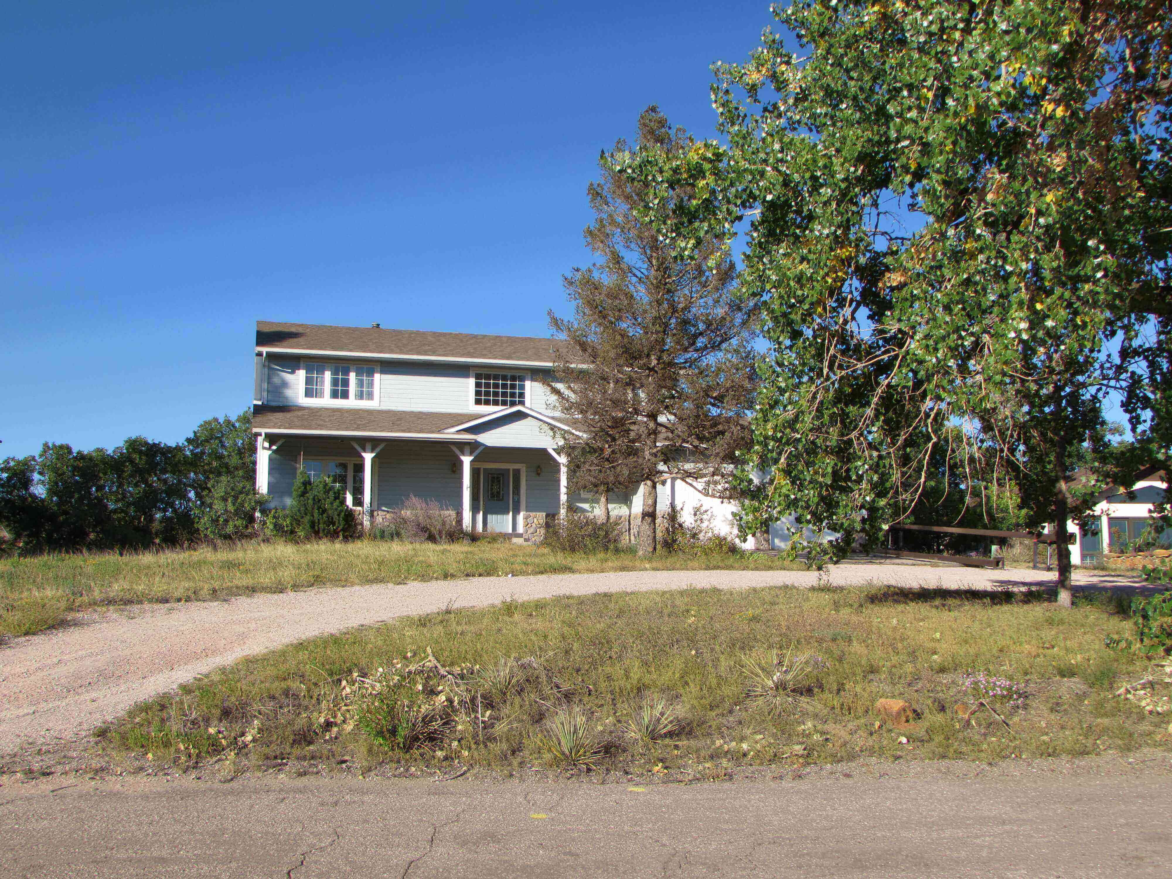 blue residential house with grass and semi-circle drive