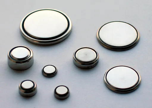 Assorted coin-cell batteries (button cells) such as CR2032, CR2025, showing common lithium primary cells.