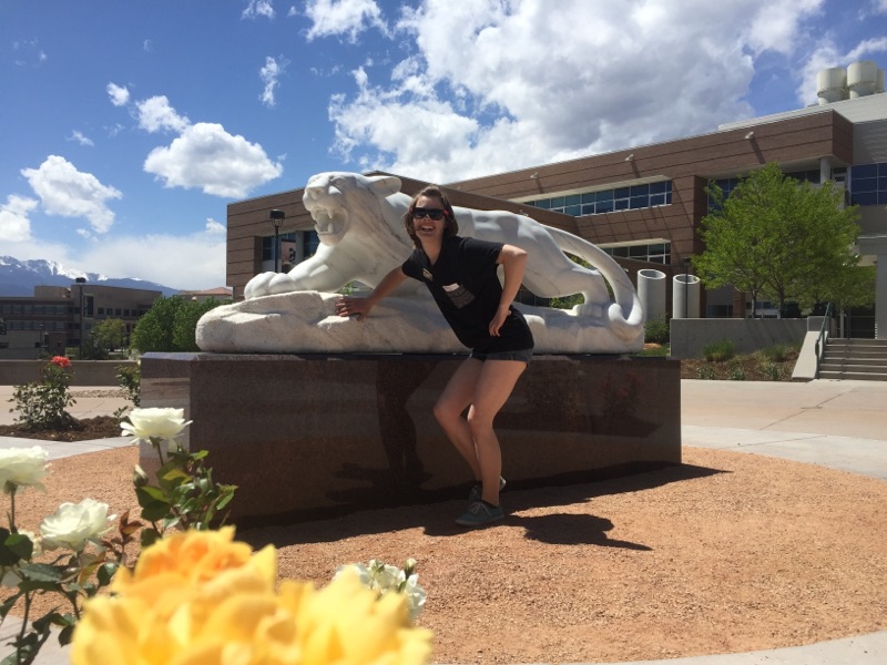 Claire standing in front of the mountain lion statue
